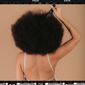 COILBAR Textured Haircare: rearview of woman with an afro and a hair pick in her hair